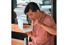 Man eating food from a styrofoam container.